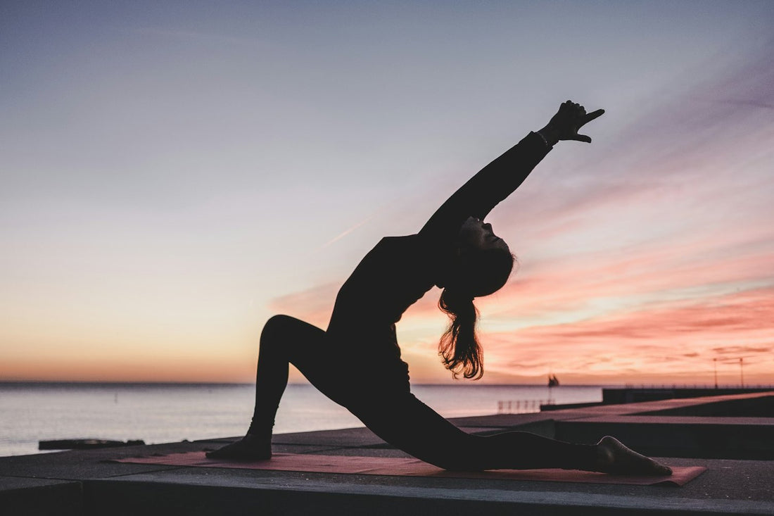 Sunset yoga pose on a mat — best eco-friendly yoga mats for beginners at home