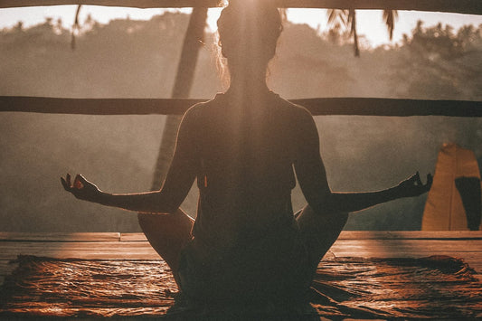 Woman meditating at sunrise — why yoga is one of the best daily habits you can build